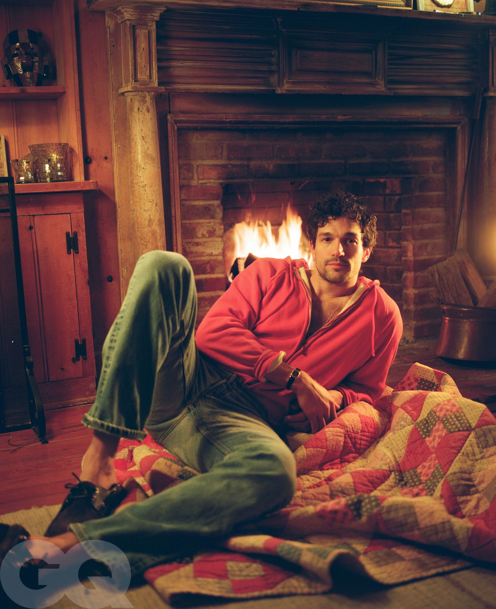 Image may contain Fireplace Indoors Clothing Pants Face Head Person Photography Portrait Adult and Hearth
