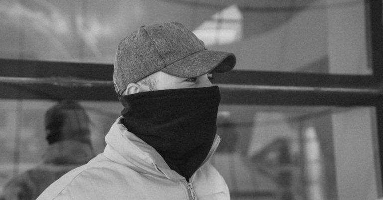 Outerwear - A man wearing a face mask and a hat