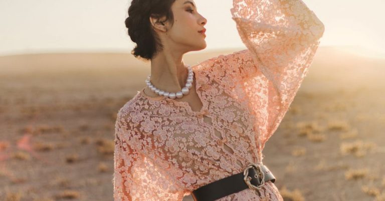 Slow Fashion - A woman in a pink dress is standing in the desert